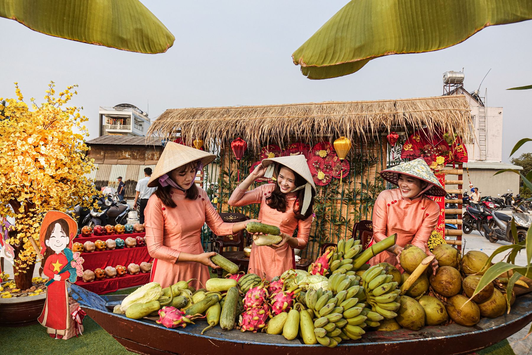Vietnamese women in ao dai selling fresh fruit at a traditional market stall